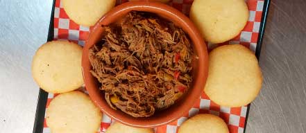 arepitas de maíz fritas, acompañadas de carne deshilachada de ternera