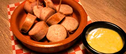 Tapa de salchicha alemana acompañada de salsa curry mango